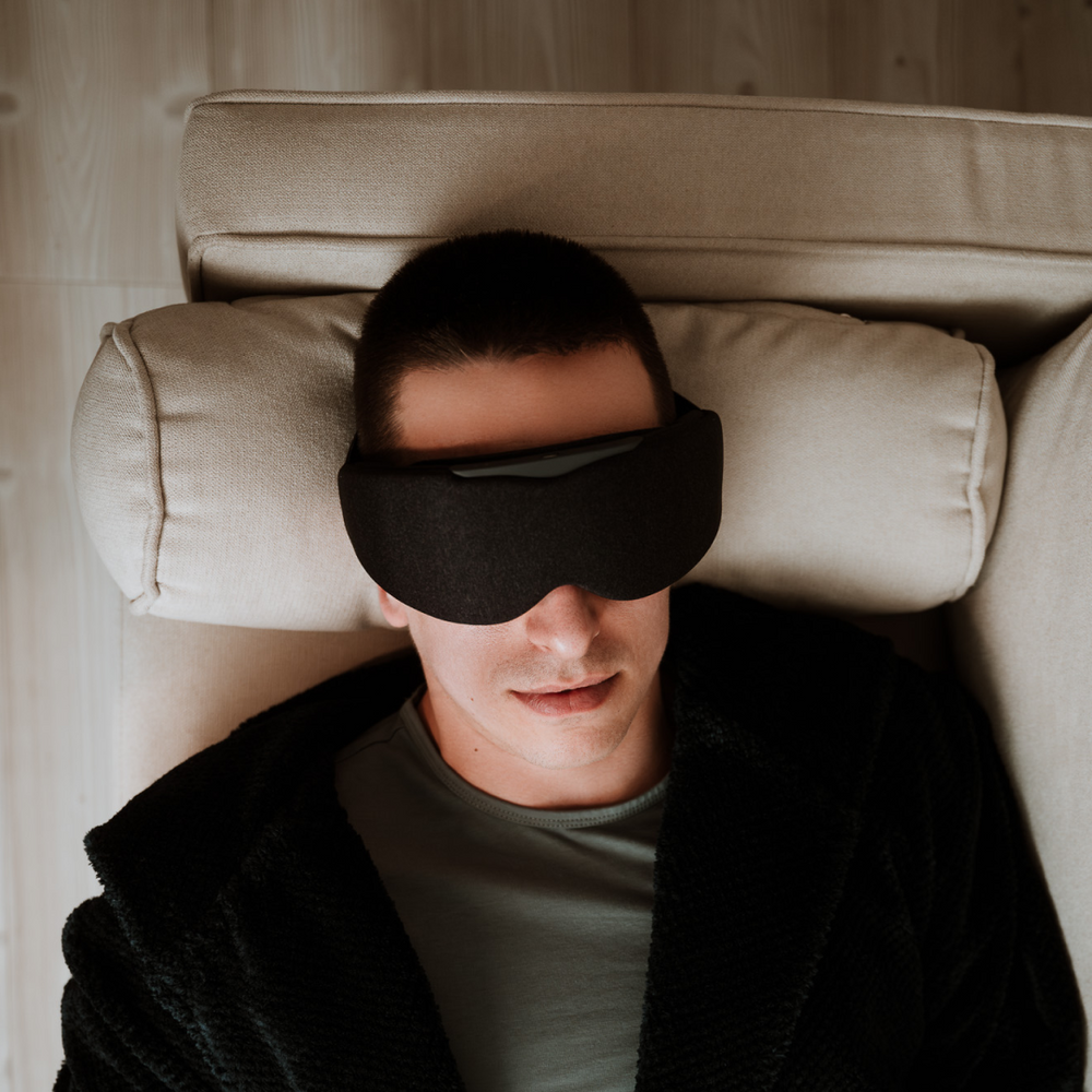 
                      
                        Man lying on a sofa and Relaxing with Aura Smart Sleep Mask in Grey
                      
                    