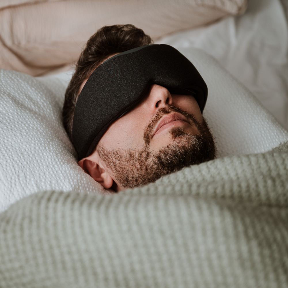 
                      
                        Man sleeping comfortably with Midnight Black Aura Smart Sleep Mask on bed
                      
                    